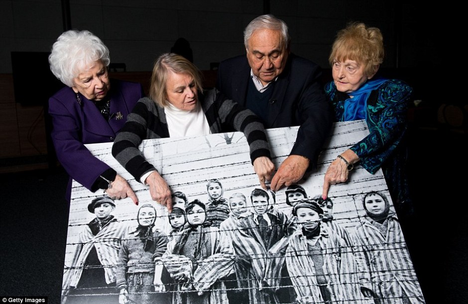 On the 70th anniversary of the liberation of Auschwitz, a group of survivors hold up and point to a picture of themselves, which was taken the day the camp was freed by the Soviet army @GettyImages